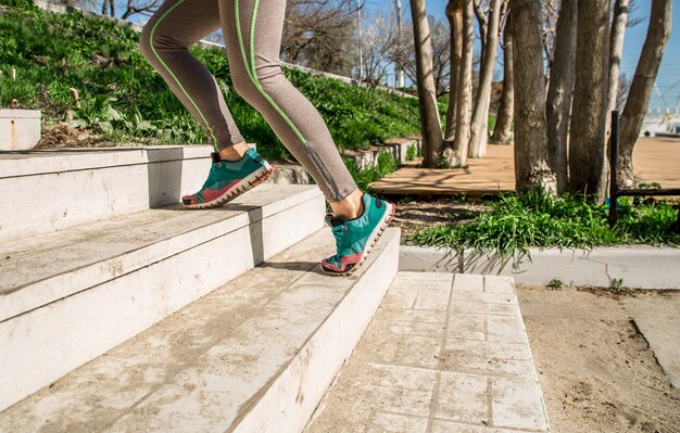Sportliche weibliche Beine steigen die Treppe hinauf