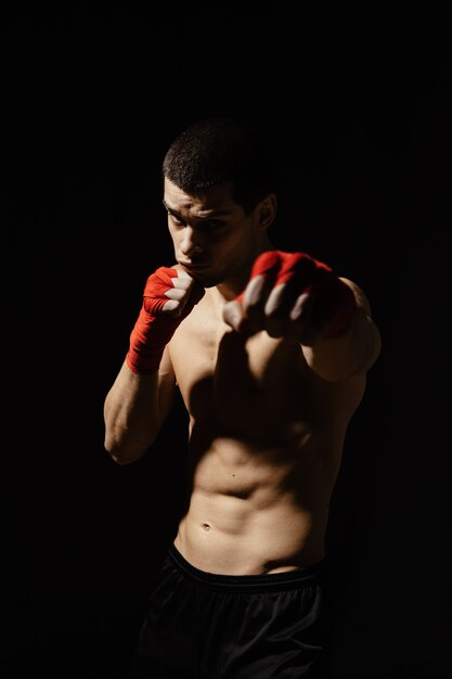 Sportlicher Boxer, der mit Entschlossenheit und Vorsicht schlägt