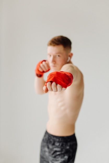 Kostenloses Foto sportlicher junger mann, der zu hause trainiert, mann, der trainiert, sich vor dem krafttraining aufwärmt.