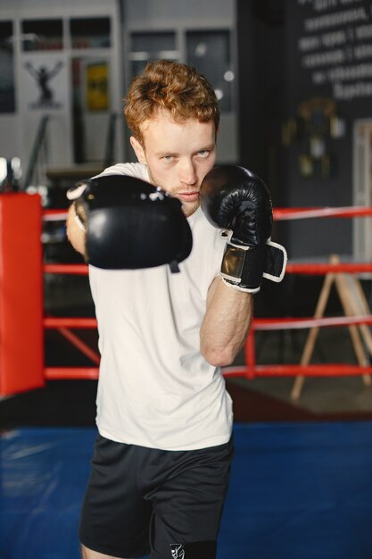 Sportlicher Mann, der boxt. Foto des Boxers auf einem Ring. Kraft und Motivation