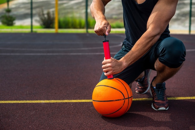 Sportlicher Mann, der eine Kugel aufbläst