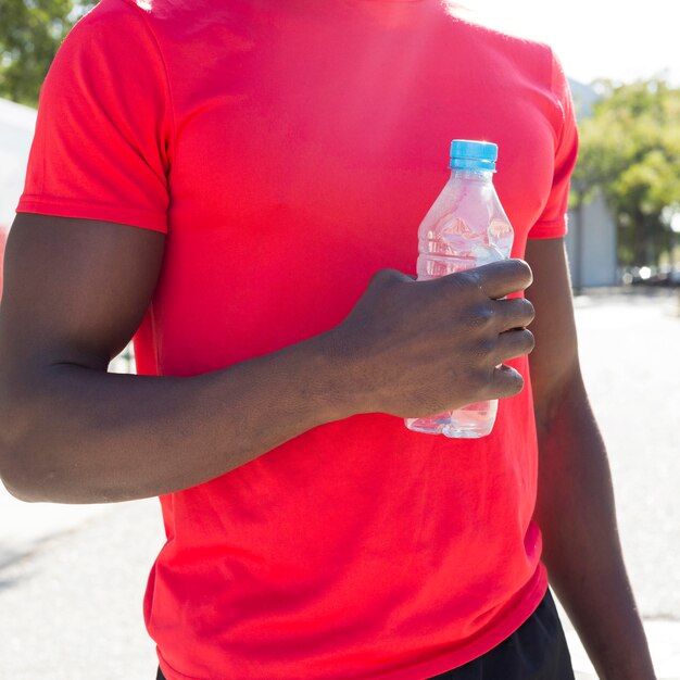 Sportlicher Mann mit Flasche Wasser