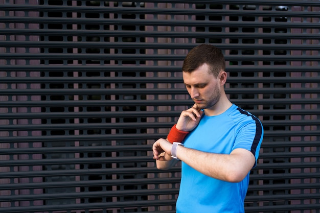 Kostenloses Foto sportlicher mann überprüft seinen puls während des stadttrainings