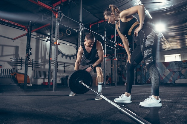 Sportlicher Mann und Frau mit Hanteln