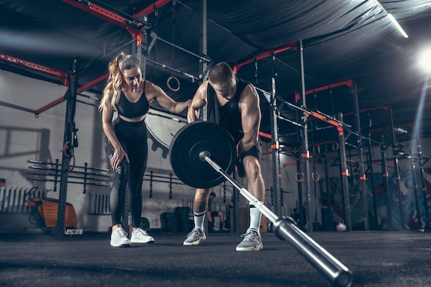 Sportlicher Mann und Frau mit Hanteln