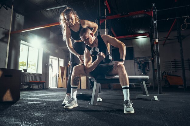 Sportlicher Mann und Frau mit Hanteln