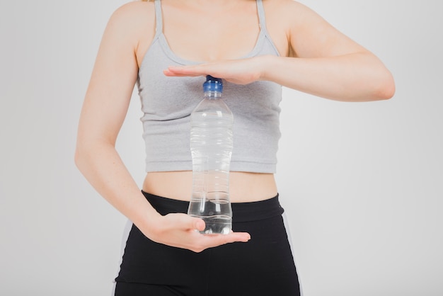 Sportliches Mädchen, das Flasche Wasser hält