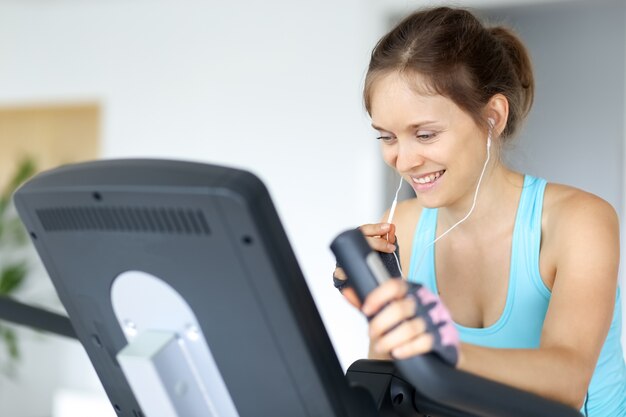 Sportliches Mädchen, das Musik und Training in der Turnhalle hört