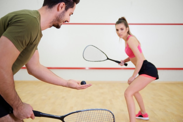 Sportliches Paar, das zusammen Squash spielt