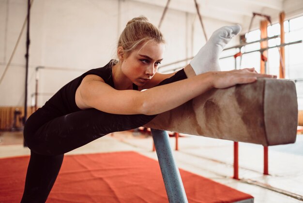 Sportliches Training der jungen Frau auf Schwebebalken