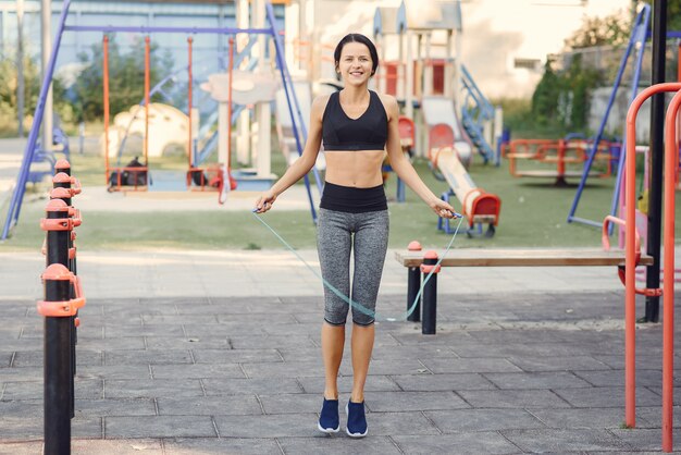 Sportmädchen in einem schwarzen Spitzentraining in einem Sommerpark