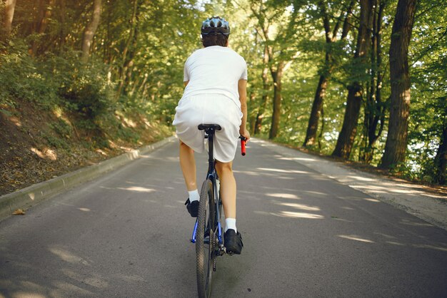 Sportmann, der Fahrrad im Sommerwald reitet