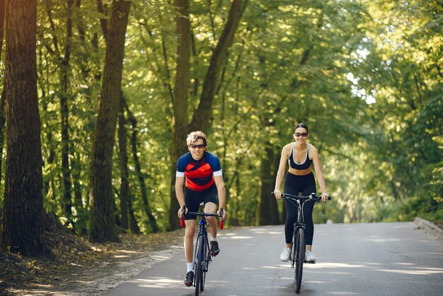 Sportpaar, das Fahrräder im Sommerwald reitet