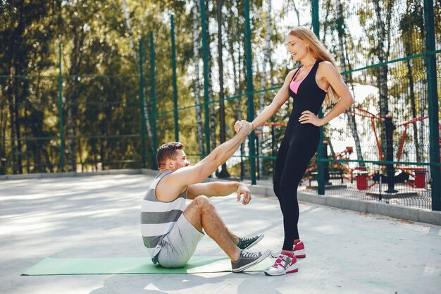 Sportpaare in einem Morgensommerpark