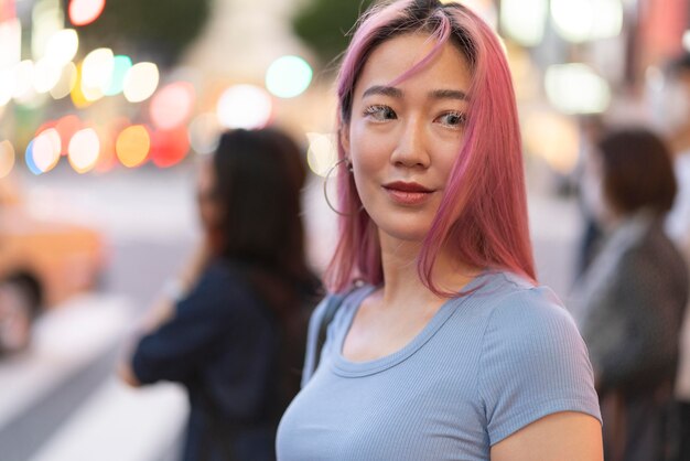 Städtisches Porträt der jungen Frau mit rosa Haaren