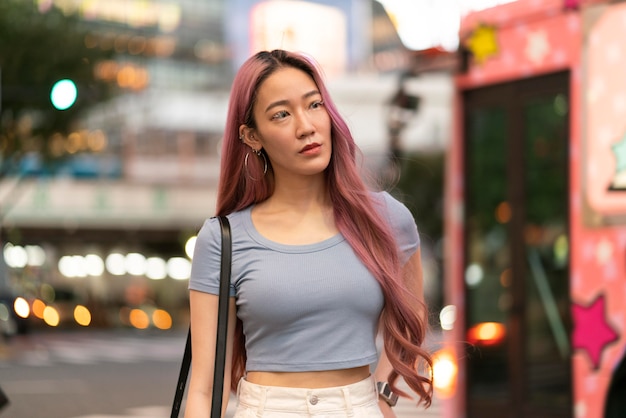 Städtisches Porträt der jungen Frau mit rosa Haaren