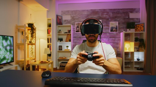 Standpunkt eines jungen Mannes, der Online-Spiele mit Virtual-Reality-Headset und Wireless-Controller spielt