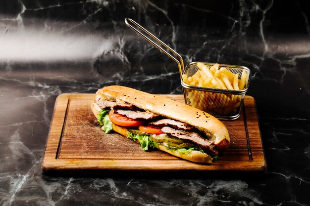 Stangenbrotsandwich mit Mischbestandteilen und Pommes-Frites.