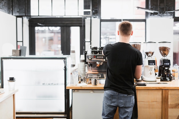 Stangenkonzept mit dem Kellner, der Kaffee macht