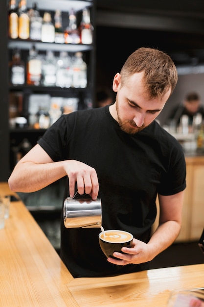 Kostenloses Foto stangenkonzept mit dem kellner, der kaffee macht