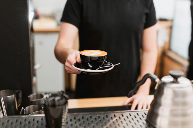 Stangenkonzept mit dem Mann, der Kaffee hält