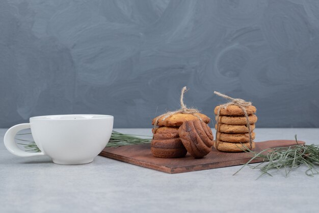 Stapel festlicher Kekse und Tasse Tee auf grauem Tisch. Hochwertiges Foto