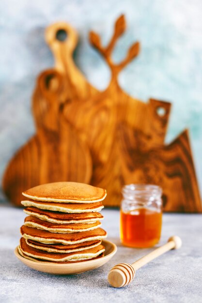 Stapel hausgemachte Pfannkuchen mit Honigsirup und Beeren.