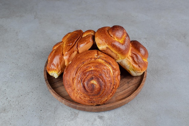 Stapel süßer Brötchen, auf einem kleinen Tablett auf Marmortisch.