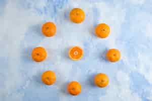 Kostenloses Foto stapel von clementinen-mandarinen auf blauer oberfläche