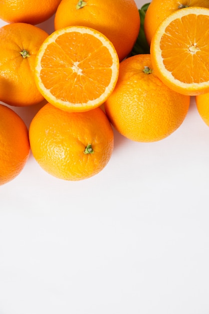 Stapel von ganzen und geschnittenen Orangenfrüchten