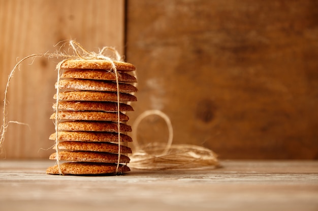 Stapel von Keksen gebunden mit Bastelseil auf Holztisch. Weihnachtsgeschenkidee.