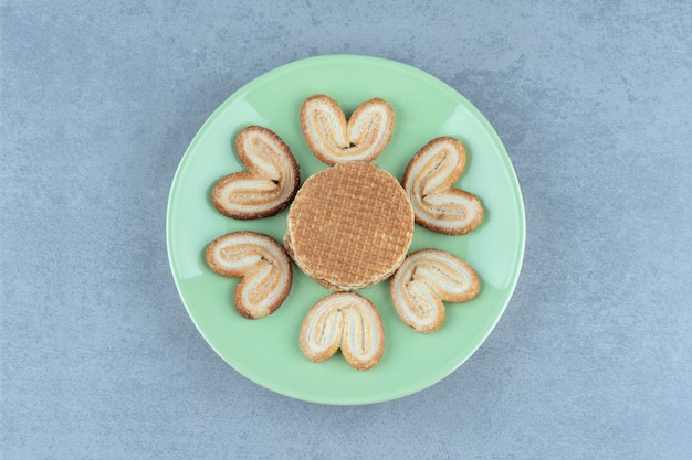 Stapel waffeln und kekse auf grüner platte.