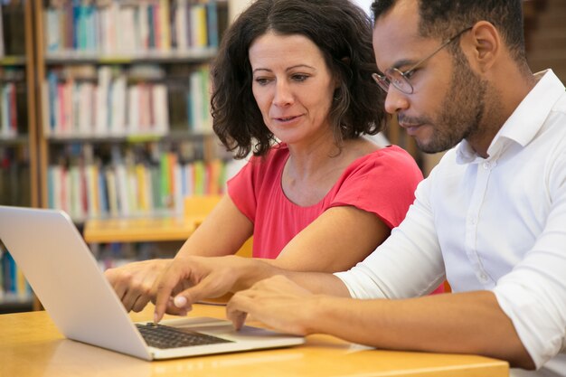 Starke Leute, die zusammen mit Laptop studieren