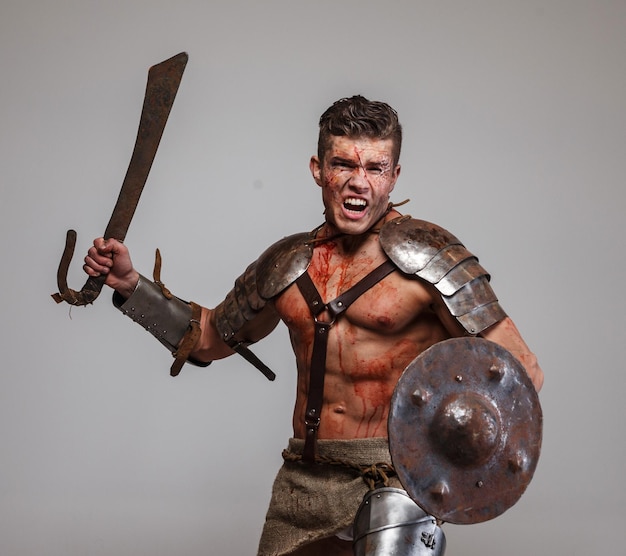 Kostenloses Foto starke muskulöse gladiatorangriffe mit schwert und schild