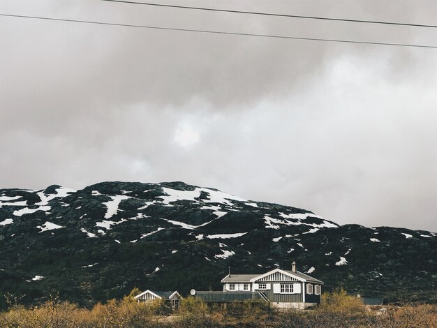 Starke Wolken hängen über die mit Schnee bedeckten Berge