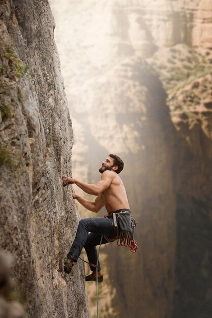 Starker Mann, der auf einen Berg klettert