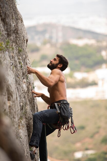 Starker Mann, der auf einen Berg klettert