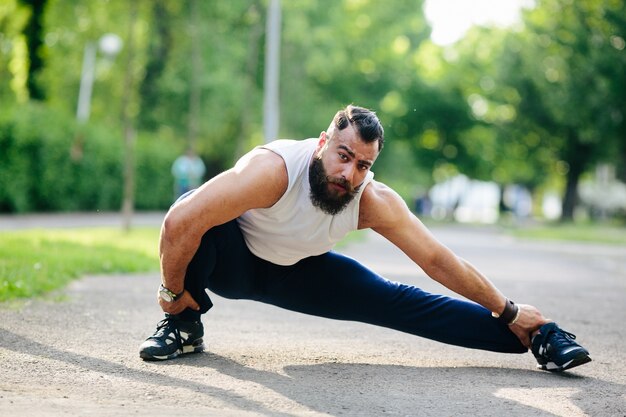 Starker Mann, sein linkes Bein Stretching