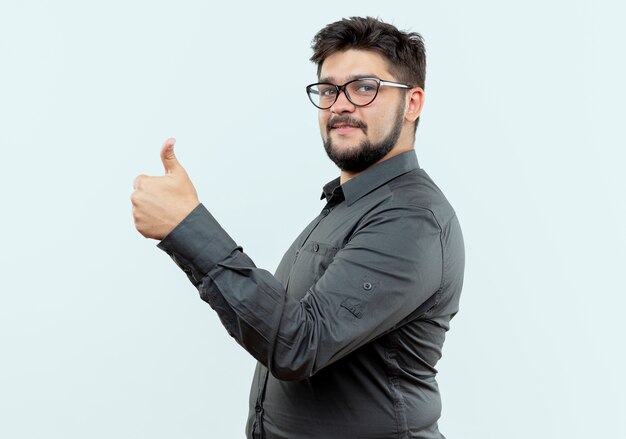 Stehen in der Profilansicht junger Geschäftsmann, der Brille seinen Daumen oben auf Weiß isoliert trägt