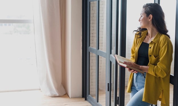 Stehende Frau der Seitenansicht mit Buch