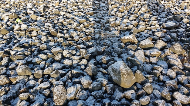 Steinbedeckter Boden mit einer dünnen Schneeschicht im Winter