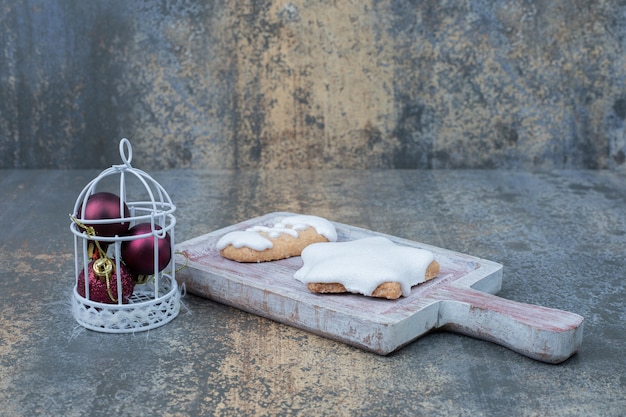 Sternförmige Lebkuchen und Bündel Kugeln auf Marmoroberfläche. Hochwertiges Foto