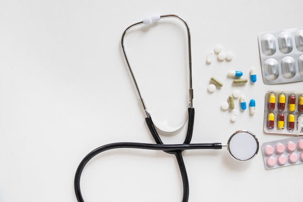 Stethoskop und Pillen mit Medizinblase auf weißem Hintergrund
