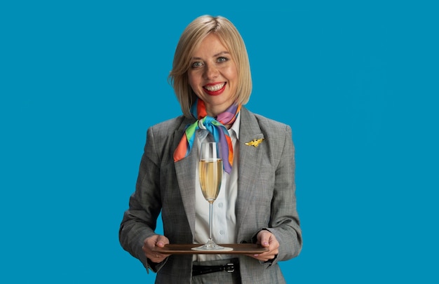 Kostenloses Foto stewardess der vorderansicht, die ein getränk hält