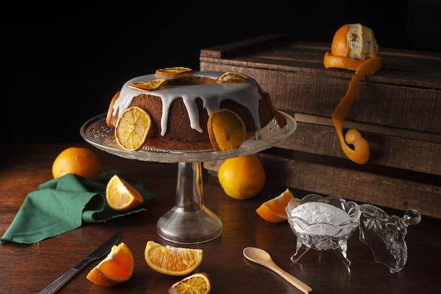 Ästhetische lebendige Aufnahme eines Orangenkuchens, der mit süßer Zuckerglasur bedeckt ist