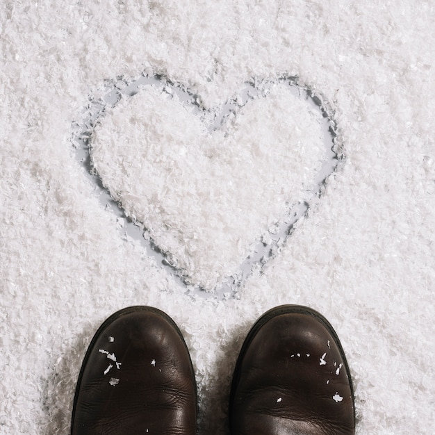 Kostenloses Foto stiefel nahe dem herzen gemalt auf schnee