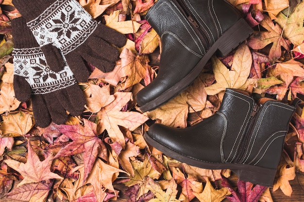 Stiefel und Handschuhe auf trockenem Blatthintergrund