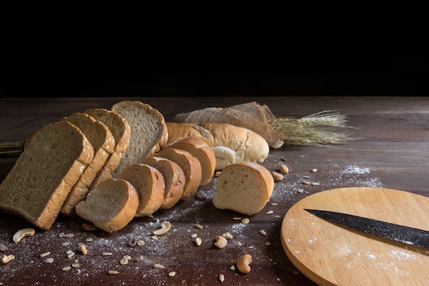 Stilleben mit Brot und Weizen auf Holztisch