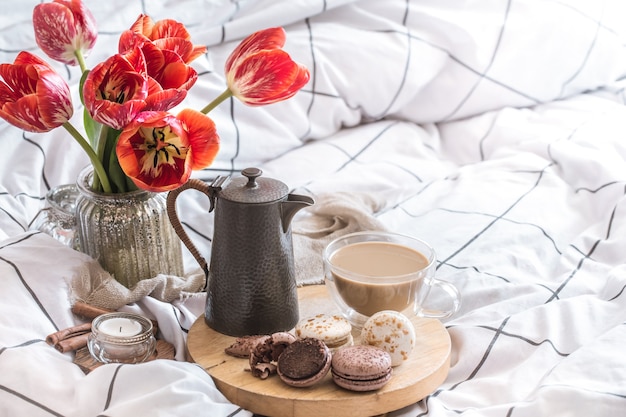 Stillleben gemütliches Frühstück mit Kaffee und Blumen im Schlafzimmer