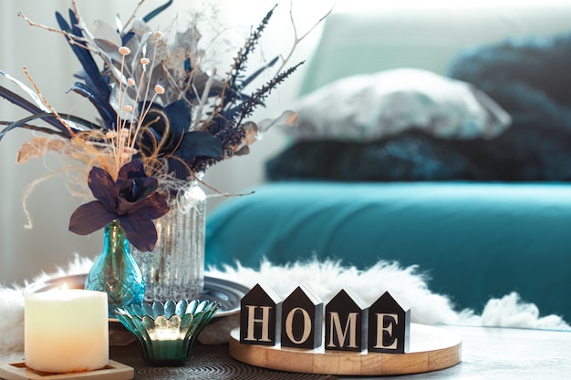Stillleben in Blautönen, mit Holzinschrift zu Hause und dekorativen Elementen im Wohnzimmer.